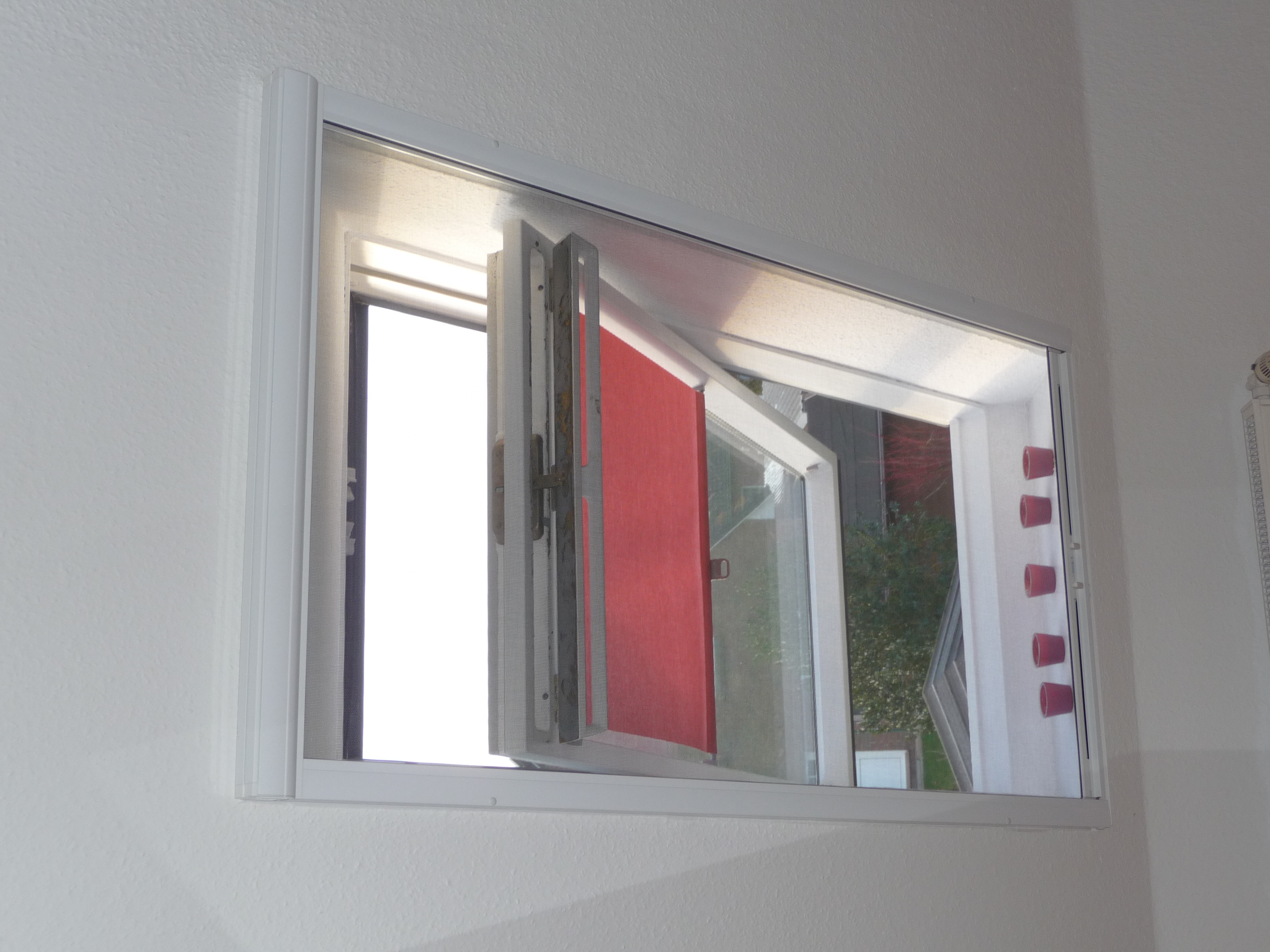 Ein weißes Insektenschutzrollo für ein Dachfenster. - Schmidt Insektenschutzrahmen GmbH